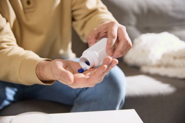 Erkek ellerinin kesilmiş fotoğrafı masaya tablet, vitamin ya da beslenme takviyesi koyuyor. Bağışıklık sistemini güçlendiriyorum. Hastalık kavramı, sağlık sigortası, ilaç, ilaç. Ad.