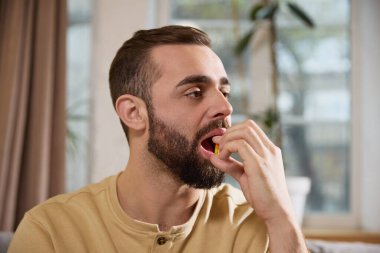 İnsanın eve hapını, vitaminini ya da diyet takviyesini, bulanık arka planda bırakması. Dokunulmazlık ve rutin. Hastalık kavramı, sağlık sigortası, ilaç, ilaç. Ad.