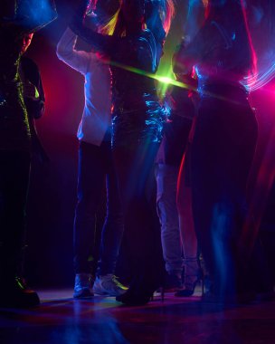Arkadaşların kesilmiş fotoğrafları, neon ışıklarının altında dans ve kadeh kaldırma anlarını müzik, kahkaha ve paylaşılan sevinç kutlamalarını kucaklıyor. Parti anlayışı, gençlik, tasasız, kutlama. ad