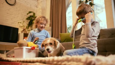 Oğlan tıbbi tedavinin eğlenceli keşifleri için oyuncak steteskop kullanıyor, kız gülüyor, sağlıklı yaşam tarzlarına olan ilgisini arttırıyor. Sağlıklı yaşam tarzı ve tıp hakkında bilgi kavramı.
