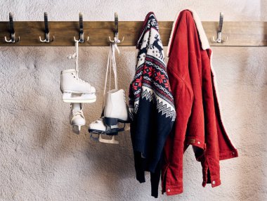 Kış kostüm ayrıntıları buz patenleri, desenli kazak ve düzgün asılı şenlikli kırmızı ceket tatil yaratıcılığını ve sıcaklığı somutlaştırıyor. Sıcak kış kavramı, tarz, estetik, rahatla.