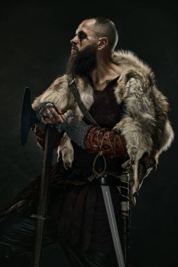 Ortaçağ Viking portresi. Kürk pelerini ve zırhlı savaşçı. Elinde savaş baltası var. Tarihsel portre kavramı, İskandinav kültürü.