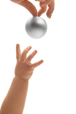 Küçük bebekler, beyaz stüdyo arka planına karşı ebeveynlerinin tuttuğu parlak gümüş topa uzanıyorlar. Merak, bağlantı, keşif, erken öğrenme kavramı.