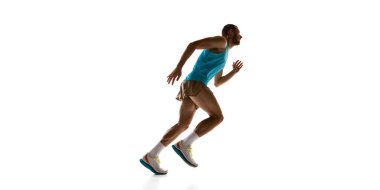 Koşucu hızlanıyor, dinamik duruş ve güçlü fizik beyaz stüdyo arka planına karşı hareketi vurguluyor. Spor, hız, rekabet ve atletik performans kavramı.