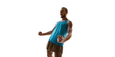 Şampiyon coşkuyu ifade ediyor, kolları açık ve yoğun yüz ifadesi beyaz stüdyo geçmişine karşı zaferi vurguluyor. Rekabet, atılım ve spor ustalığı kavramı.