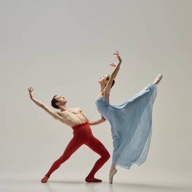 Partnerin beyaz stüdyo arka planına nazikçe baktığı ve kolunu uzattığı sırada balerin bacaklarını kaldırıyor. Esneklik, sanatçılık, yoğunluk, adanmışlık kavramı.