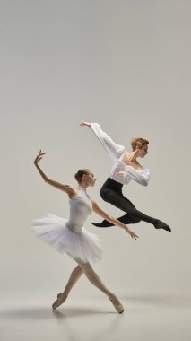 Bale dansçıları senkronize sıçrama yapıyorlar, kollar ve bacaklar tamamen akışkan, beyaz stüdyo arka planına karşı ağırlıksız hareket ediyorlar. Güç kavramı, özgürlük, güzellik, sanat, ifade.