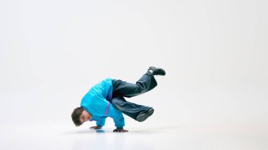 Serbest stil dansçı, modaya uygun giyinmiş eski moda kıyafetler, havada kontrolü gösteren taklalar, dinamik hareketlerle kendini ifade etme. Sanatsal mükemmellik kavramı, şehir sporları, performans, enerji, akış.