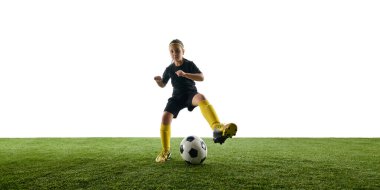 Kız, siyah üniformalı çocuk ve sahada salya süren sarı çoraplı çocuk, beyaz stüdyo arka planında topu kontrol etmeyi öğreniyor. Spor, çocukluk, oyun, rekabet, etkinlik kavramı