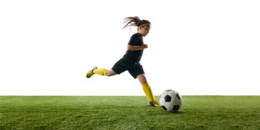 Yetenekli genç kız, futbol becerilerini gösteriyor çimenli alanda kontrollü bir şekilde top sürüyor, beyaz stüdyo arka planına karşı. Spor, çocukluk, hareket, rekabet, etkinlik kavramı