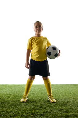 Kendine güvenen kız, sarı formalı çocuk ve siyah şortlu gururla futbol topuyla birlikte beyaz stüdyo arka planında duruyor. Şampiyon. Spor, çocukluk, oyun, rekabet, etkinlik kavramı