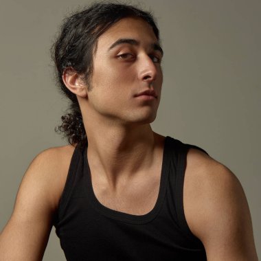 Parlak derili genç adamın yan profili tarafsız bir arkaplana bakıyor. Erkek güzelliği, cilt bakımı, kişisel bakım, kozmetik, reklam, sağlık, bakım.