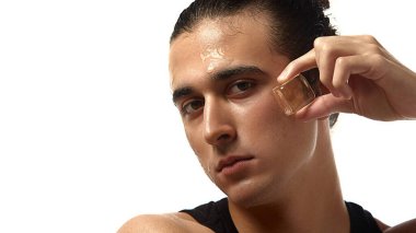 Alnına buz küpü bastırılmış, genç, ıslak ve ışıl ışıl cilt, beyaz stüdyo arka planında serinletici bir etki yaratıyor. Cilt bakımı, güzellik, kozmetik, su..