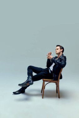 Klasik giyinmiş bir adam, zahmetsizce dinleniyor, sigara sonsuz özgüvenle yakılıyor, stüdyo arka planına karşı sinemanın özünü somutlaştırıyor. Sanat, müzik, bağbozumu, yetenek kavramı