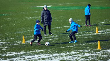 Bir grup genç sporcu aktif futbol talimine katıldılar, koçluk hareketleri, soğuk hava antrenmanları. Tutku ve sıkı çalışma. Geliştirme, spor, motivasyon, takım çalışması, büyüme kavramı.