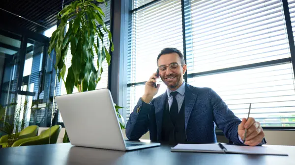 Hevesli girişimci telefonda konuşurken gülümserken, görüşmeleri yönetirken ve ofiste iletişim kurarken. Kurumsal başarı kavramı, iletişim, iş bağlantıları, liderlik.