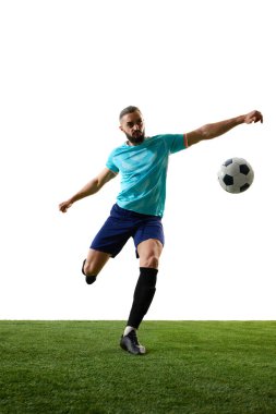Mavi üniformalı futbolcu topun orta sahada dengelenmesi, kolları açık, beyaz arka plana karşı yeşil sahada güçlü bir saldırıya hazırlanıyor. Rekabet kavramı, turnuva, kesinlik, başarı.