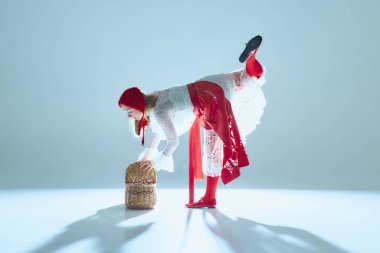 Hassas bir hareketle sepetin üzerinde dengede duran zarif genç kadın, kırılgan gücü ve vücudun şiirsel kontrolünü simgeliyor. Gerçeküstü moda kavramı, psikolojik hikaye anlatımı, bale hareketi, güzellik..