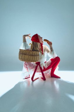 Yanında sepet ve ekmeğe düşkün genç bir kadın, mizah ve duygusallığı harmanlayarak dizginleme ve arzu arasındaki zıtlığı sembolize ediyor. Sanat ve moda kavramı, gerçeküstü güzellik, fantezi.