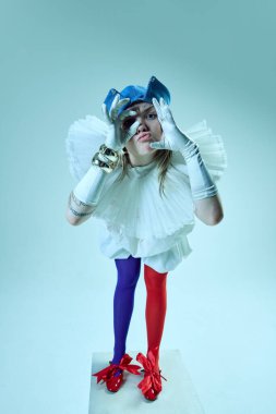 Büyük yakalı ve eldivenli yenilikçi kıyafetli, parmaklarıyla abartılı jestler yapan neşeli ama yapılandırılmış estetiği vurgulayan etkileyici bir kadın. Kendini ifade etme kavramı, moda.