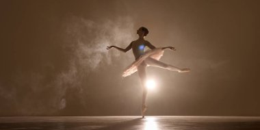 Zarif arabesk dansçısı, parlak siluet etrafında yükselen altın sis, klasik güzelliği arttıran yumuşak ışık. Performans, bale, hareket, zarafet, ritim, duygusal derinlik kavramı.