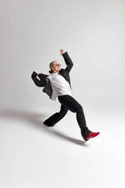 Kendine güvenen, iri yarı, resmi giyinmiş genç bir kadının dinamik portresi, büyük bir adım at, beyaz arka plana karşı yeni iş zorluklarına atla. Kariyer büyümesi ve kişisel gelişim kavramı, iş.