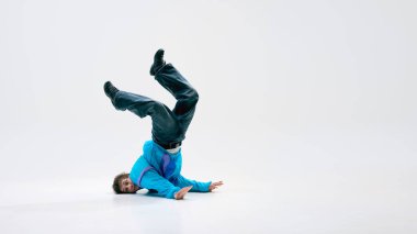 Bacakları açık bir şekilde baş aşağı dengede duran, fiziğe meydan okuyan, beyaz arka planda negatif alana karşı mükemmel bir kontrole sahip bir sokak dansçısı. Müzik, sanat, hareket, kendini ifade, adanmışlık kavramı