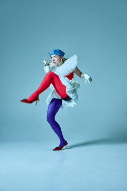 Canlı tayt giymiş, yapılandırılmış kıyafet giymiş, bacakları kalkık, eksantrik zarafeti ön plana çıkaran bir kadın. Moda yoluyla hikaye anlatma kavramı, cesur görsel kimlik, alternatif kadınlık.