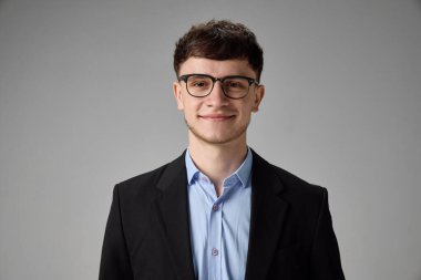 Resmi tişörtlü ve gözlüklü gülümseyen genç adam, kendine güven ve profesyonellik saçıyor. Modern iş atmosferi kavramı, kurumsal markalaşma, kişisel kimlik, girişimcilik.