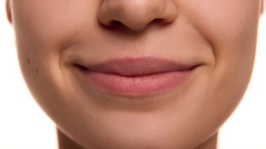 Sağlıklı ciltli, tombul, nemli, beyaz arka planda pembe dudaklı bir kadın yüzü. Gençlik ve doğal güzellik kavramı, kozmetik tedavisi, kozmetik, kaplıca. Ad