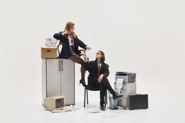 Kabinedeki zarif kadın, patronuna kahve getiren meslektaşına abartılı güç gösterisi jesti olarak evrak dağıtıyor. Ofis hayatı kavramı, insan duyguları, sosyal meseleler, iş.