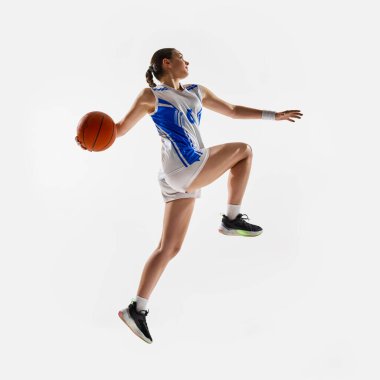 Smaç basıldı. Beyaz arka planda skor elde etmek için havada sıçrayan formda genç bir kızın yan görüntüsü. Profesyonel spor anlayışı, kadın spor, hareket, fitness. Ad