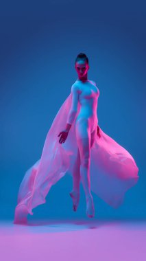 Zarif balerin, yüzen kumaşa sarılmış neon ışığın içinden atlıyor, balenin güzelliğiyle vücudun üstünlüğünü simgeliyor. Hareket, dans ve özgürlük kavramı.