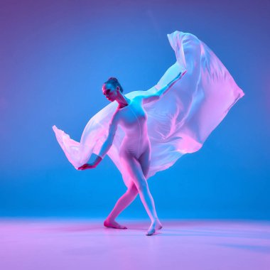 Pembe şeffaf kumaş ışığı yakalar ve neon ışıkta zarafeti temsil eden eğimli arka plana karşı sembolik kanatlar oluşturur. Bale, güzellik, dans, müzik, özgürlük kavramı.