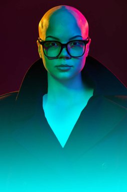 Kendine güvenen bakışları olan kel bir kadının portresi ve parlak parlak siyanür pembesi renginde gözlükleriyle gücü ifade ediyor. Güzellik, moda, tarz, eşitlik, duygu kavramı, .