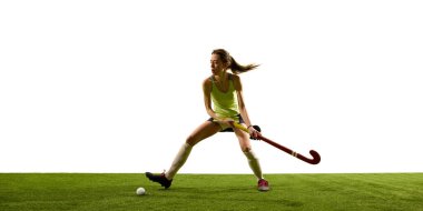 Çim hokeyi oyuncusu, bayan atlet, yeşil sahada aktif duruşu sürdürürken titiz salya sürme tekniği sergiliyor. Spor müsabakaları, yarışma, şampiyonluk, oyun, hareketler..