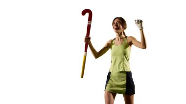 Beyaz stüdyo arka planına karşı yeşil çimlerde yükseltilmiş sopa ve neşeli ifade ile zafer pozu. Zaferin kutlaması. Spor etkinlikleri kavramı, yarışma, şampiyonluk, oyun, hareketler.