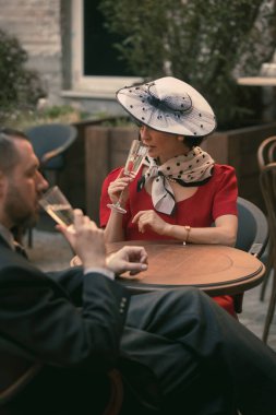 Kadın ve erkek şampanyayla oturur ve nazikçe konuşurlar. Zarif, eski moda kıyafetlerle. Nazik sevgi. Birbirine aşık klasik bir çift. Gizlenmek için uygun. Bağbozumu, aşk, nostalji kavramı