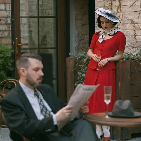 Güzel, zarif bir kadın yumuşak bir yüzle aşağı bakar erkek dışarıda kağıt okurken. Aralarındaki boşluk sessiz kelimelerle dolu. Klasik, aşk, nostalji, romantik randevu kavramı. Gizlenmek için uygun.