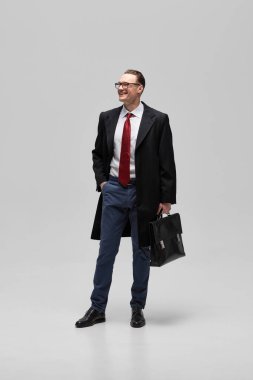 Profesyonel giyinmiş, resmi giyinmiş, evrak çantalı beyaz stüdyo arka planına karşı, iş görüşmeleri için hazırlanmış. Politik tartışmalar ve stratejik planlama kavramı.