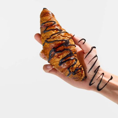 Çikolata serpiştirilmiş kruvasan ve beyaz stüdyo arka planında karışık kıvrılan bilek şurubu. Fast food, paket servis, yemek, geleneksel beslenme, öğle yemeği kavramı..