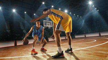 Bileşik kolaj. Mavi formalı basketbolcu, 3 boyutlu basketbol sahasında sarı üniformalı defans oyuncusu ve arkasında da seyirci var. Spor anlayışı, rekabet, turnuva.