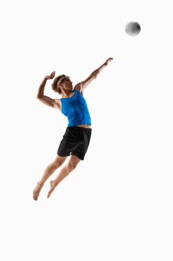 Genç atletik adam, atlama pozisyonunda voleybol oyuncusu. Kolunu geriye çekip beyaz stüdyo geçmişine karşı güçlü bir servis hazırlıyor. Şampiyonluk kavramı, maç, aksiyon, hız, hareket