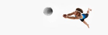 Pankart. Sporcu, kritik bir anda topu yakalamak için kolları önde, beyaz stüdyo arka planına karşı negatif alanla yan yana uçar. Spor, enerji, maç, rekabet kavramı