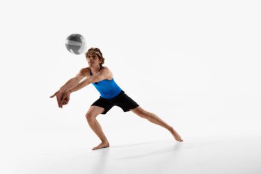 Voleybol atleti, beyaz stüdyo arka planına karşı yoğun oyun anında topu almaya hazır ellerle yukarı bakıyor. Şampiyonluk kavramı, enerji, maç, hareket. Ad