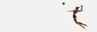 Pankart. Havada voleybol oynayan atletik bayan voleybol oyuncusu, beyaz atölyenin arka planına vuruyor. Spor, voleybol etkinliği ve oyun momentumu kavramı.