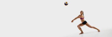 Pankart. Voleybolcu, beyaz stüdyo arka planında reklam koymak için negatif alana sahip rakiplerine karşı topa doğru sıçrıyor. Spor zamanlaması, üniforma, rekabet