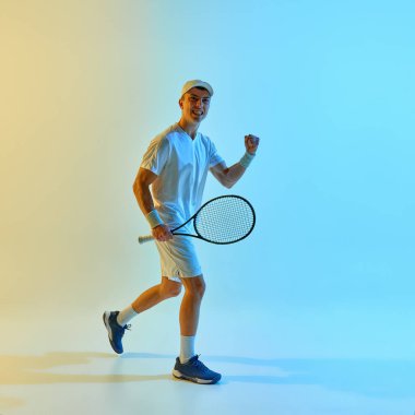 Hareket halindeki mutlu tenisçi, sıcak neon ışıkta parlak mavi-sarı gradyan arkaplana karşı kazanma enerjisiyle ilerliyor. Spor başarısı, motivasyon, turnuva kutlaması kavramı.