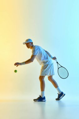 Tenis sporcusu servise hazırlanıyor, gözler topta, sıcak neon ışıkta mavi-sarı gradyan arka plana karşı durmaya hazır. Odaklanma konsepti spor, oyun başlıyor, atletik hazırlık.