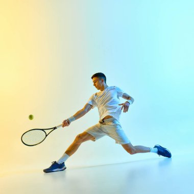 Neon gradyan altındaki yetenekli oyuncu, yukarı bakıyor ve sıcak neon ışıkta çarpan mavi-sarı gradyan arka plana karşı servis atıyor. Profesyonel spor anlayışı, hizmet anı